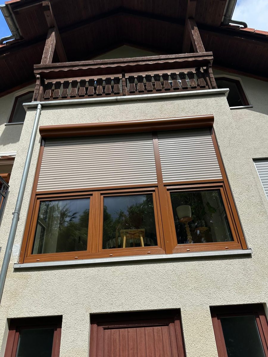 Fassade mit Rollläden und Holzbalkon
